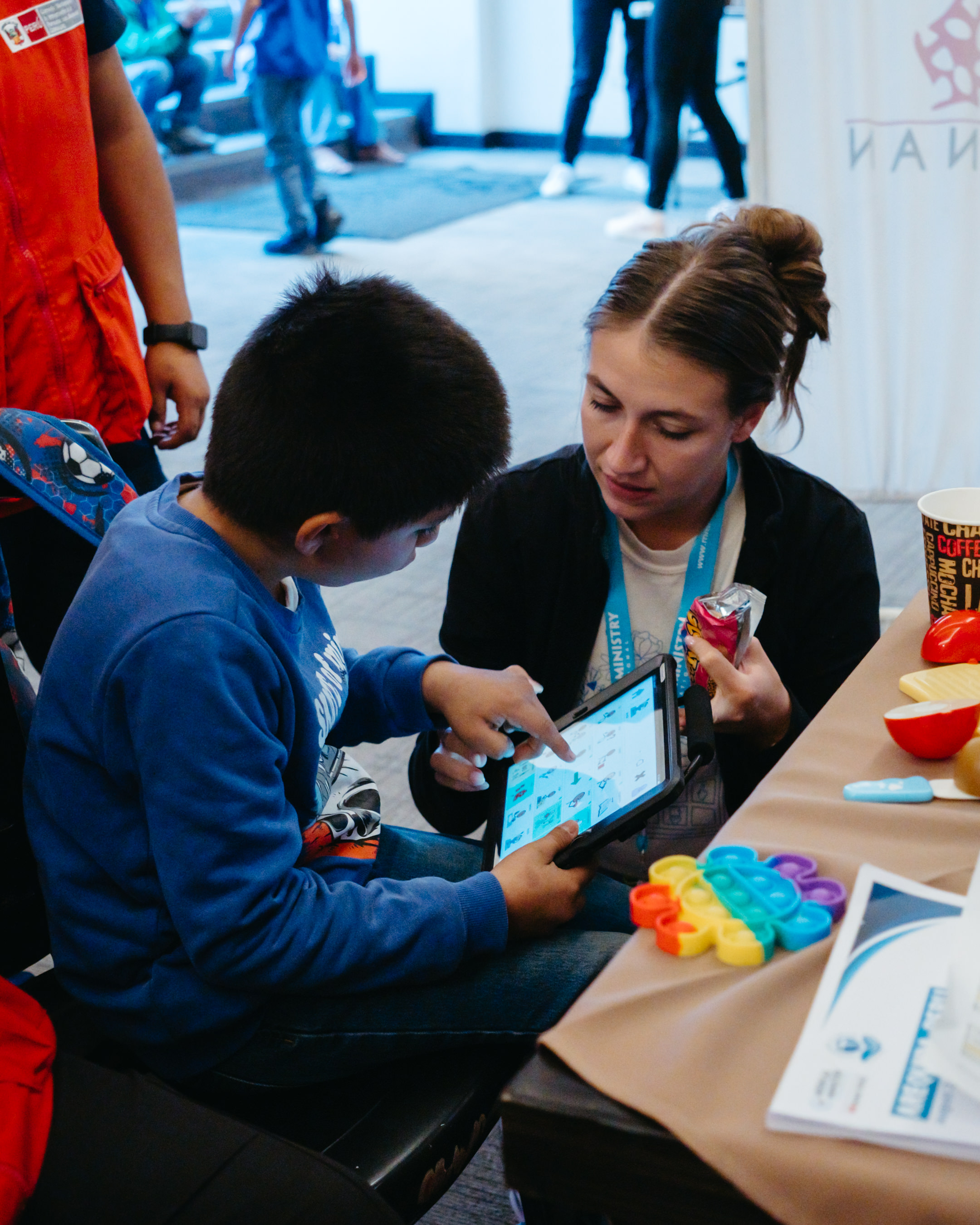 Busy Bee SLP therapist supporting a child with an AAC device